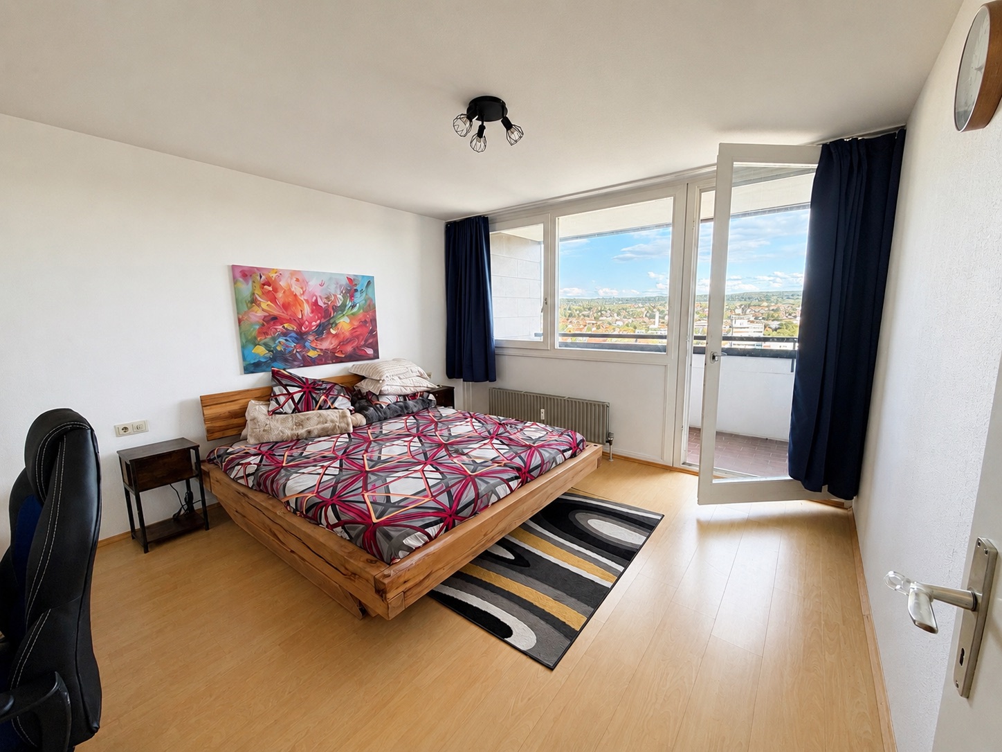 Schlafzimmer mit Massivholzbett und Balkonzugang